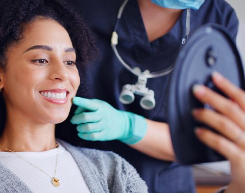 a patient admiring her smile in a mirror