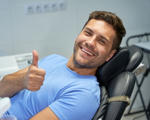 Happy dental patient making thumbs up gesture