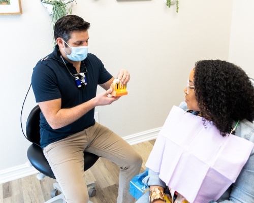 Docor Salayta showing a dental patient how dental implants work