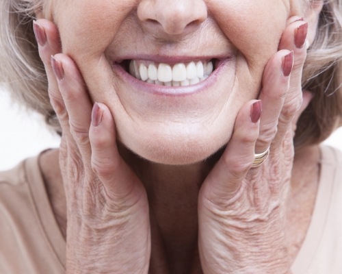 Close up of smiling senior woman touching her cheeks