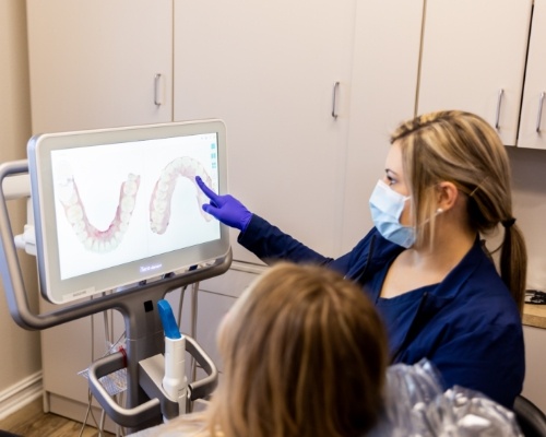 Dental team member showing a patient digital impressions of their teeth on computer monitor