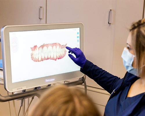 Dental team member showing a patient digital images of their teeth