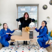 Three Jenks dental team members gesturing to a stereo system on a table