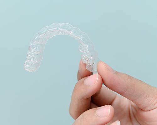 Closeup of patient holding clear aligner