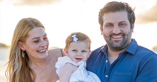 Doctor Salayta smiling with his wife and baby daughter