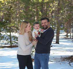 Doctor Salayta with his wife and daughter in a forest with snow on the ground