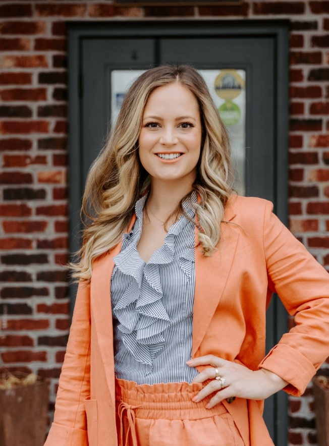Doctor Schuyler smiling while standing in front of brick wall