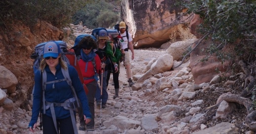 Doctor Schuyler hiking up a rocky path with a group of people
