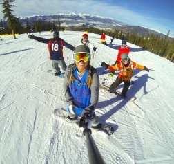 Doctor Schuyler wearing ski gear on a snowy mountain with several other people