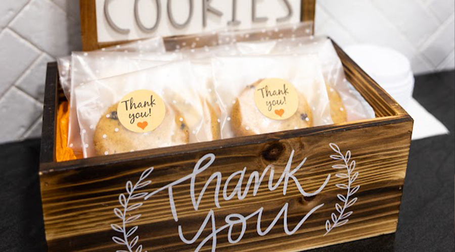 Individually wrapped chocolate chip cookies in a wooden box that says thank you