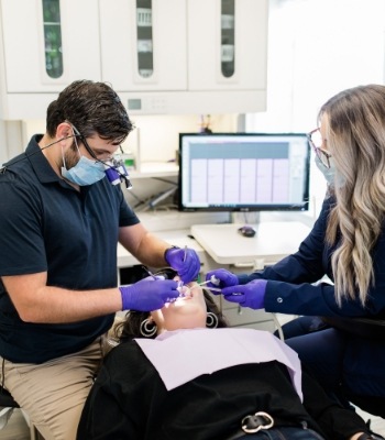 Doctor Salayta and dental team member giving a patient a teeth cleaning