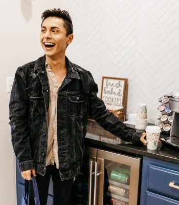 Young man grinning and holding coffee cup in dental office