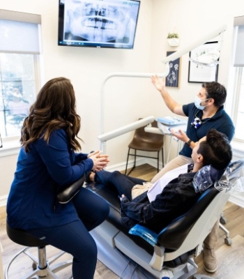 Dentist and dental team member showing a patient x rays of their teeth