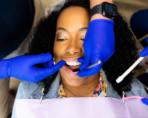 Dentist performing an oral cancer screening on a patient