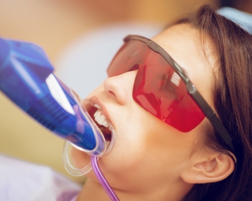 Young girl receiving fluoride treatment from her dentist