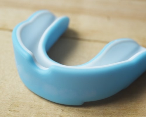 Light blue athletic mouthguard on a wooden surface