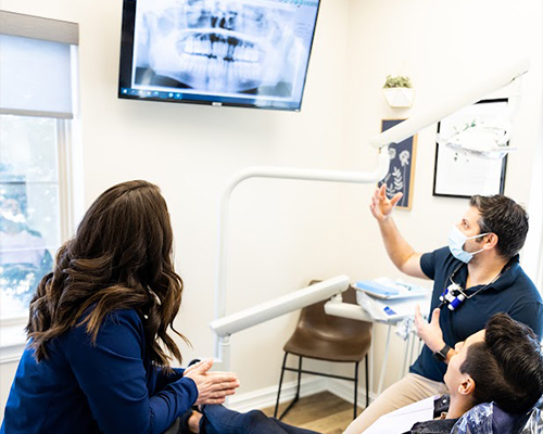 Dentist and team member showing a patient their dental x rays