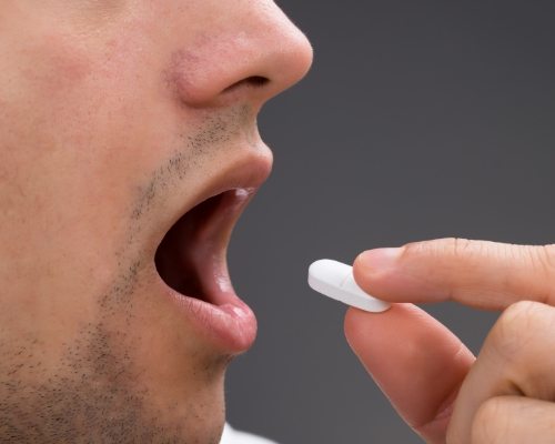 Man about to take a pill for sedation dentistry in Jenks