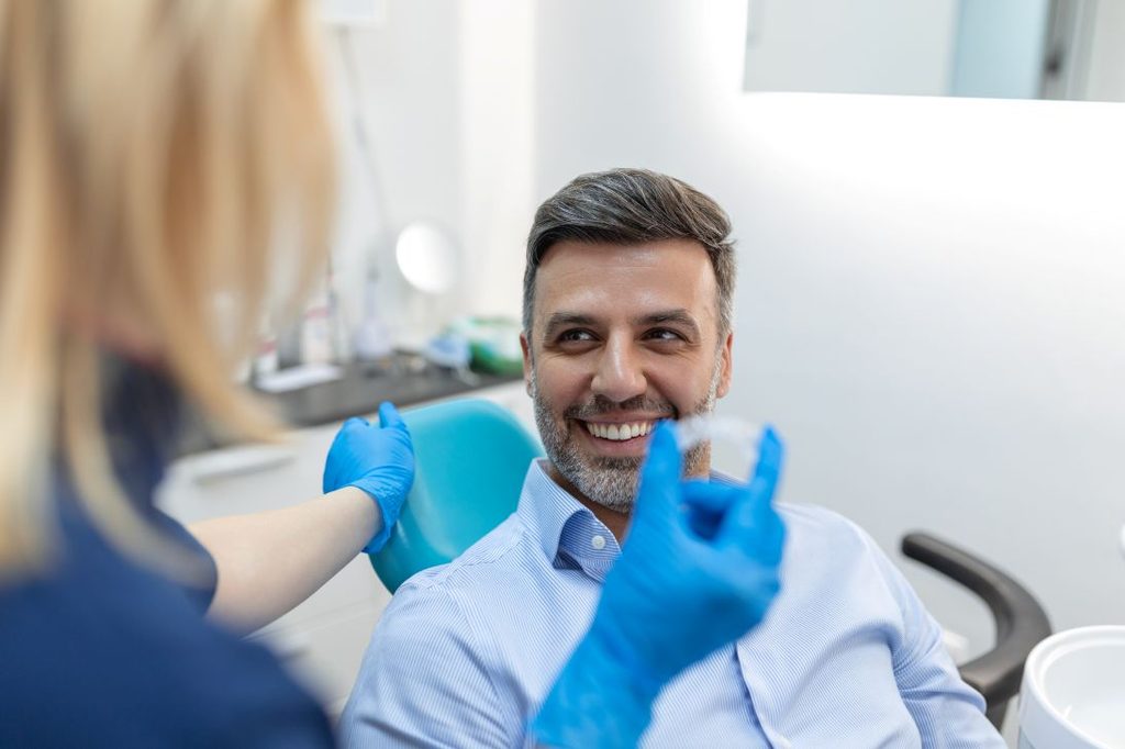 A man getting Invisalign aligners from his dentist